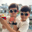 Two children taking a selfie with colorful sunglasses and building blocks.
